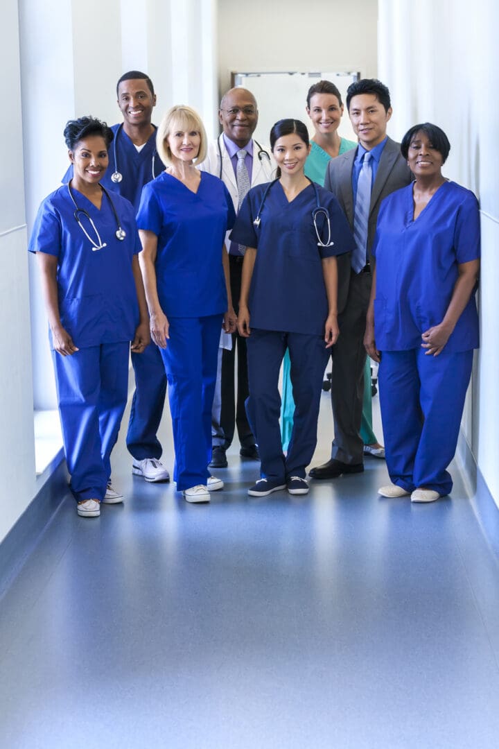 Portrait smiling multi ethnic male female medical team in uniform planning patient treatment in modern hospital